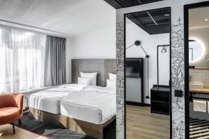 a hotel room with a bed and a mirror at Pentahotel Rostock in Rostock