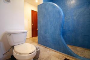 La salle de bains est pourvue de toilettes et d'un mur bleu. dans l'établissement Coco Resort & Villas, 
