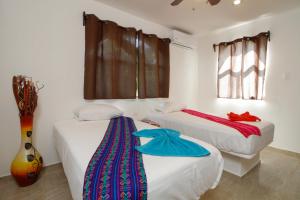 Cet hébergement comprend 2 lits dans une chambre dotée de murs blancs et de fenêtres. dans l'établissement Coco Resort & Villas, 