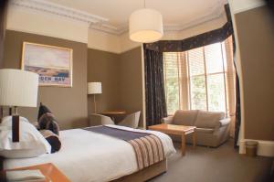 a bedroom with a bed and a couch and a window at The Dutch Mill Hotel in Aberdeen