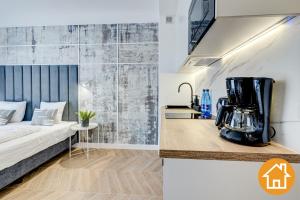 a room with a bed and a blender on a counter at Apartamenty Promenada - visitopl in Świnoujście