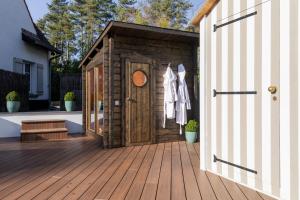 a wooden shed on a deck with a door at Villa Raphia - Maison d'hôtes in Hardelot-Plage +1 photo