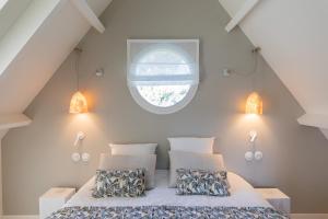 1 dormitorio con 1 cama y ventana redonda en Villa Raphia - Maison d'hôtes, en Hardelot-Plage