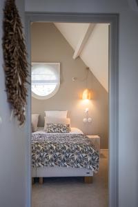 1 dormitorio con cama y ventana en Villa Raphia - Maison d'hôtes en Hardelot-Plage