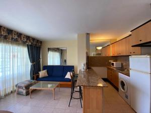 a kitchen and a living room with a blue couch at APARTAMENTO CERCA DEL PASEO Y PORT AVENTURA in Salou +4 photos