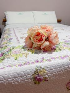 Um monte de rosas cor-de-rosa em cima de uma cama. em CASA VACANZE DA RITA. em Stintino