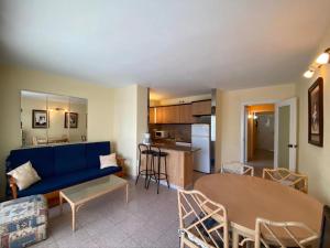 a living room with a blue couch and a table at APARTAMENTO CERCA DEL PASEO Y PORT AVENTURA in Salou