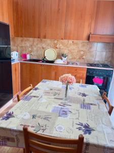 una cocina con una mesa con un jarrón de flores. en CASA VACANZE DA RITA., en Stintino