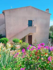 a building with a staircase in a garden with flowers at CASA VACANZE DA RITA. in Stintino