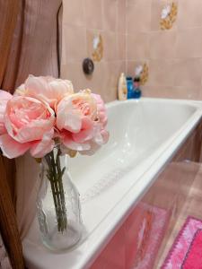 a vase of pink flowers sitting on a counter in a bathroom at CASA VACANZE DA RITA. in Stintino