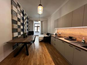 cocina y sala de estar con mesa y sofá en Apartamenty Rynek 5 en Lublin