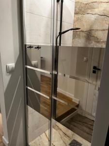 uma cabina de duche em vidro numa casa de banho com uma escada em Apartamenty Rynek 5 em Lublin