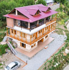 una vista aérea de una casa con techo rojo en ThePahadians Food & Stay en Jibhi