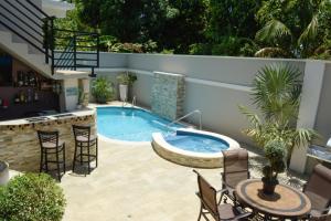 un patio con piscina, tavoli e sedie di Pineridge Hideaway 1 Bedroom Apartment #1 ad Arouca