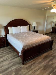 a bedroom with a large bed with a wooden headboard at Shore Stay Suites in Cape Charles