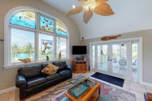a living room with a leather couch and stained glass windows at The Mermaid Manor in Cudjoe Key