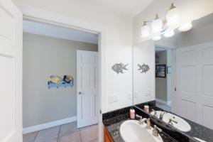 a bathroom with a sink and a mirror at The Mermaid Manor in Cudjoe Key +30 photos