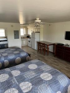 a bedroom with two beds and a kitchen with a table at Shore Stay Suites in Cape Charles