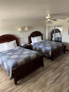 a hotel room with two beds and a mirror at Shore Stay Suites in Cape Charles