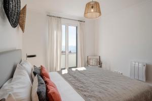 a bedroom with a large bed with a large window at Casa do Castelo by An Island Apart in Funchal