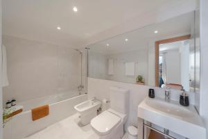 a white bathroom with a toilet and a sink at Casa do Castelo by An Island Apart in Funchal +43 photos