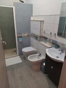 La salle de bains est pourvue de toilettes, d'un lavabo et d'une douche. dans l'établissement Lungomare Bed rooms, à Santa Maria Navarrese