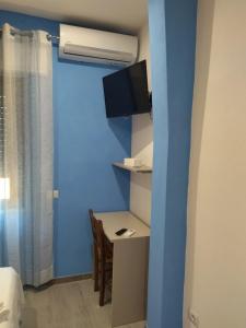 a small room with a desk and a room with a bed at Lungomare Bed rooms in Santa Maria Navarrese