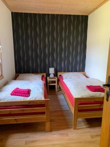 two beds in a room with black and gray wallpaper at Pension Lausa in Lausa