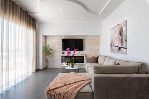 uma sala de estar com um sofá e uma televisão em Big blue suites gf em Ierápetra