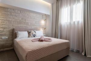 Un dormitorio con una cama con una toalla encima. en Big blue suites gf, en Ierápetra