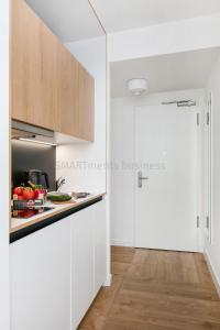 a kitchen with white cabinets and a counter top at SMARTments business Berlin Prenzlauer Berg in Berlin