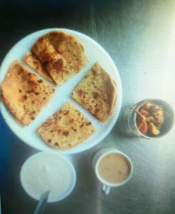 a plate of food with pancakes on a table at Hotel Sukhman Residency in Amritsar