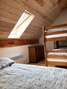 a bedroom with two bunk beds and a skylight at WIEJSKI APARTAMENT W DOMU NAD JEZIOREM in Mikołajki
