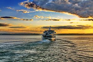 ein Kreuzfahrtschiff auf dem Wasser bei Sonnenuntergang in der Unterkunft Teddybärenhotel in Kressbronn am Bodensee