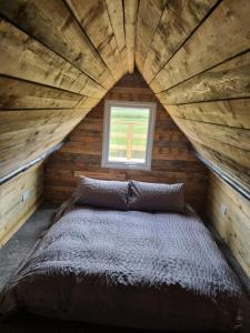 Łóżko w drewnianym pokoju z oknem w obiekcie The Thatchie w mieście Deal