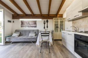 een keuken en een woonkamer met een bank en een tafel bij Sa Domixedda in Cagliari