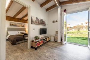 een slaapkamer met een bed en een televisie en een glazen schuifdeur bij Sa Domixedda in Cagliari
