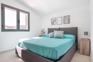 a bedroom with a large bed with blue sheets at Villa Costamante con piscina privata in Balata di Baida