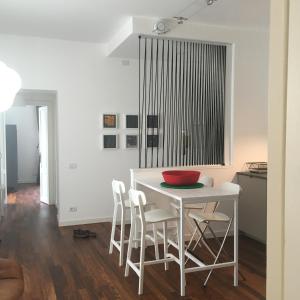 - une cuisine blanche avec une table et des chaises blanches dans l'établissement JOIVY Stylish Apt in Centre of Cernobbio, à Cernobbio