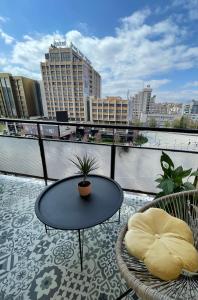 une table et des chaises sur un balcon avec vue sur une ville dans l'établissement Cozy Bright Central, à Pristina