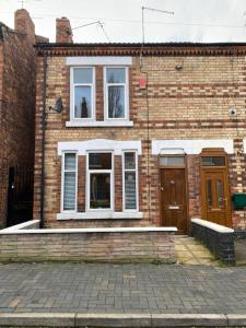 a brick house with two windows and a door at Spacious 4-bed house in Crewe by 53 Degrees Property, ideal for Contractors & Business, FREE parking - sleeps 7 in Crewe