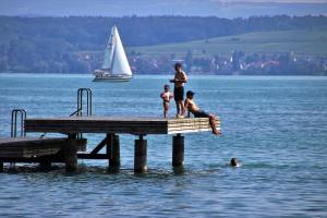 a man and two children standing on a dock in the water at Teddybärenhotel in Kressbronn am Bodensee