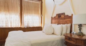 um quarto com uma cama branca e uma cabeceira em madeira em Teller House em Silverton