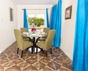 a dining room with blue curtains and a table and chairs at Mariner Suites in Christ Church