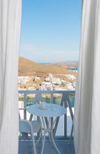 a table and chairs on a balcony with a view at Karai, The House Project in Astypalaia Town