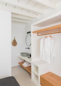 a bathroom with white walls and a sink in a room at Karai, The House Project in Astypalaia Town