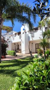 a view of a white house with palm trees at Apartamentos Hacienda Sajorami in Zahora