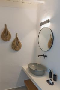 a bathroom with a sink and a mirror on the wall at Karai, The House Project in Astypalaia Town