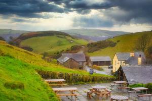 un grupo de mesas de picnic al lado de una colina en Blue Ball Inn, en Lynmouth