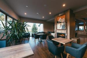 een restaurant met tafels en stoelen en een open haard bij Hotel Arena Maribor in Maribor